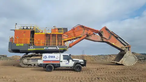 DWA Industrial Resources ute parked beside a Macmahon excavator