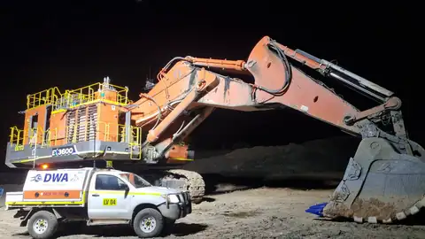 Excavator lit up during a night shift